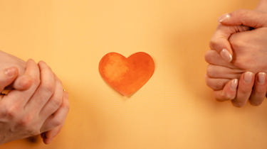 to sett med foldede hender med et hjerte i midten.