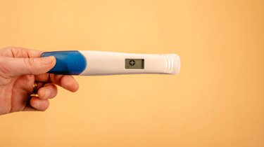 Hånd som holder en graviditetstest.