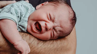 Spedbarn med kolikk som gråter