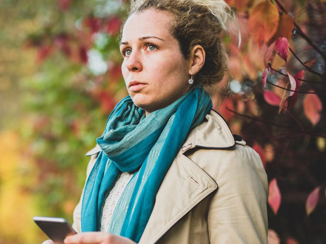 kvinne 40 titter bekymret ut i luften. høstbakgrunn. foto.