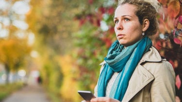 kvinne 40 titter bekymret ut i luften. høstbakgrunn. foto.