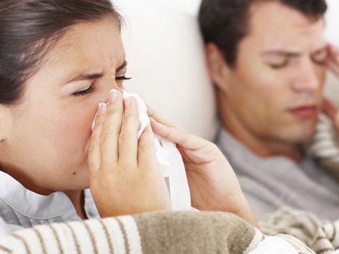 Forkjølet par som ligger i sengen