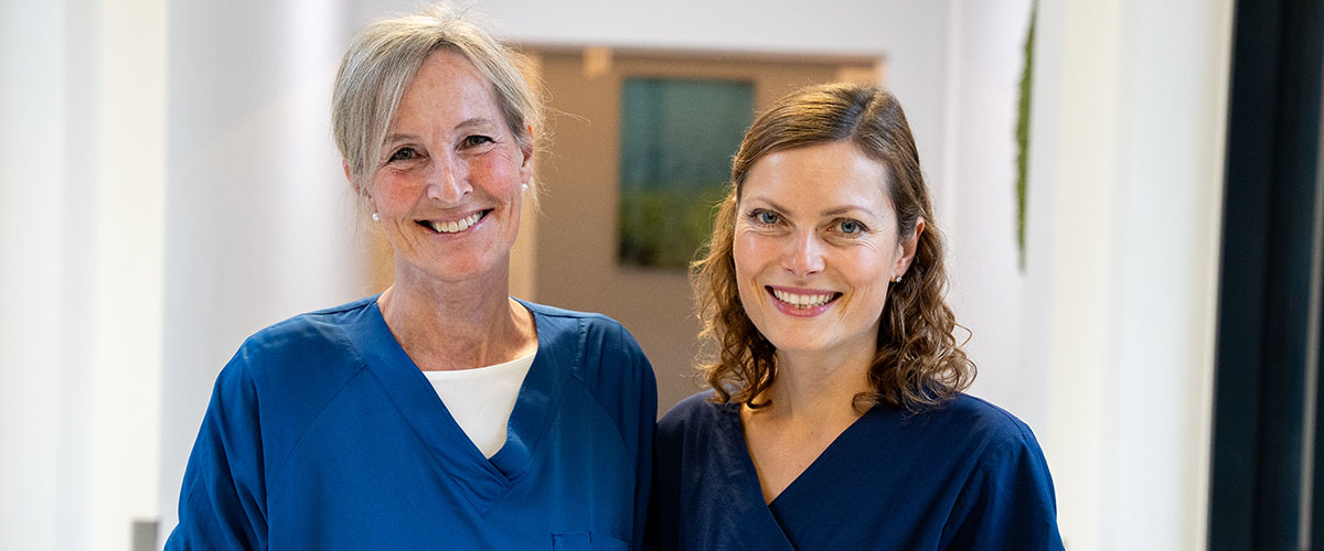 To kvinnelige leger som smiler til kamera. 