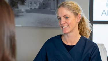 Gynekolog Tone R. Hafsteen i konsultasjon med mørkhåret kvinne.