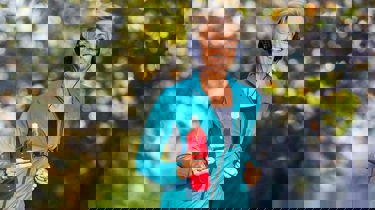 Middelaldrende kvinne jogger fornøyd med en drikkeflaske i hånden. høstlig bakgrunn.