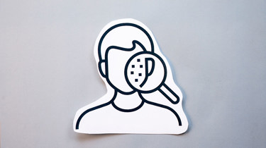 illustrasjon av et ansikt med noen prikker som sees gjennom et forstørrelsesglass.