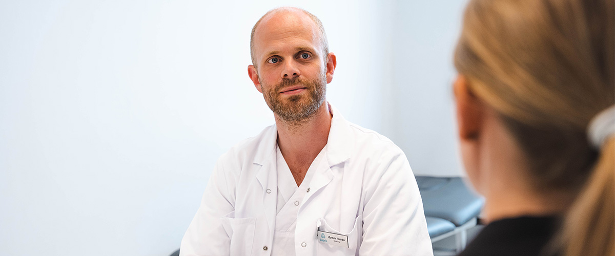 onkolog Flatebø i konsultasjon med kvinnelig pasient. 