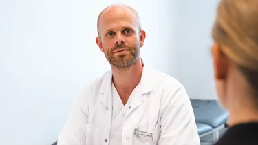 onkolog Flatebø i konsultasjon med kvinnelig pasient.