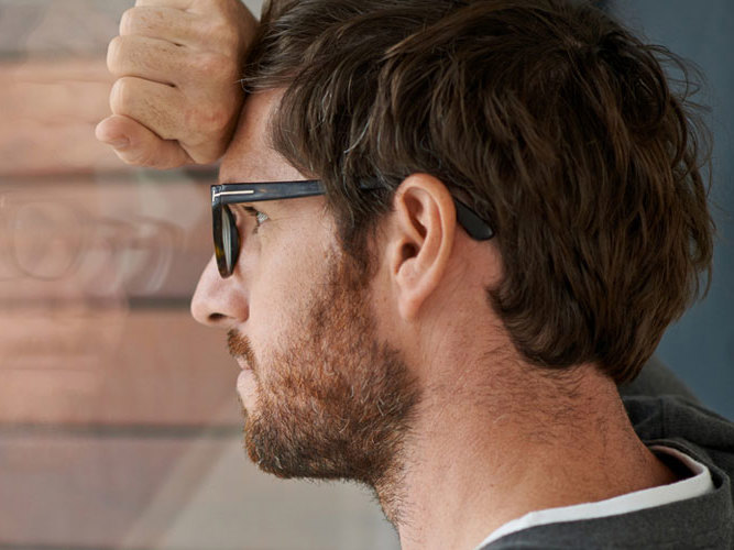 bekymret mann lener seg mot vindu.