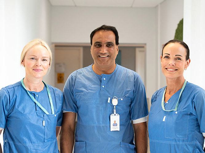 Tre smilende ansatte som arbeider ved gastrolabben.