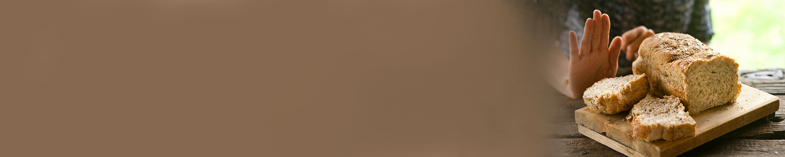 En hånd som sier nei takk til brød som inneholder gluten.