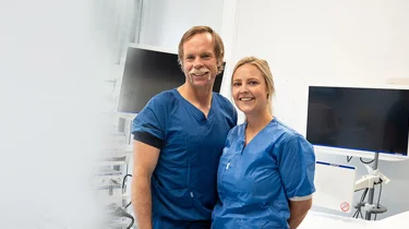 En mann og en kvinne smiler til kamera. Begge to arbeider på Aleris gastroavdeling.