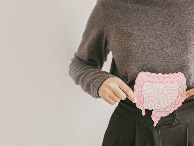 Hender som holder en lyserosa tegning av tarmen.