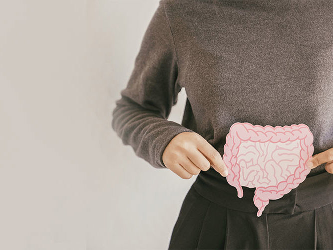 Hender som holder en lyserosa tegning av tarmen.