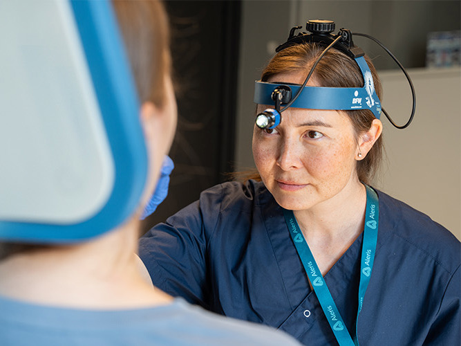 Øre-nese-halsspesialist undersøker pasient.