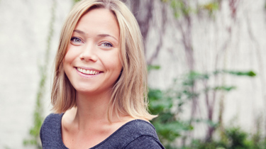 Jente som smiler fornøyd til kamera etter laseroperasjon