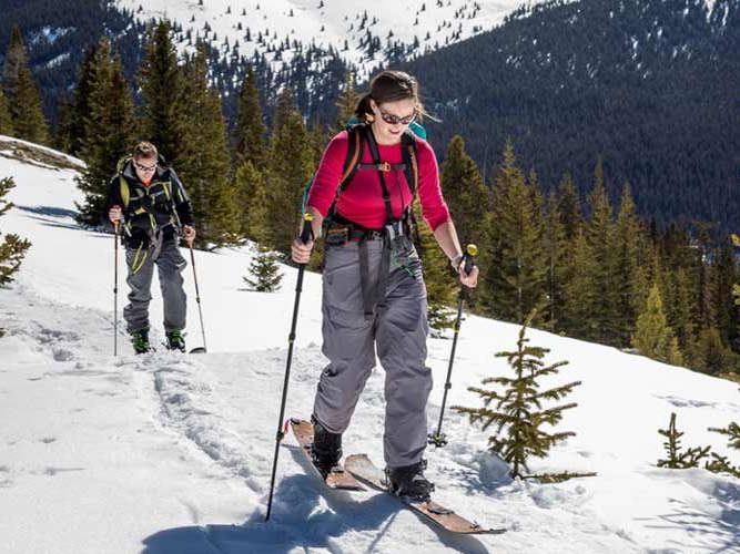 Sporty par på skitur i fjellet.