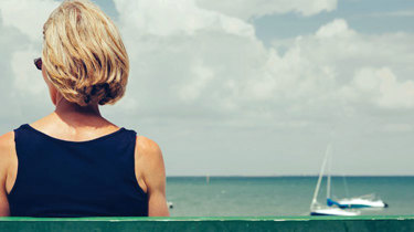 Kvinne sitter på en benk