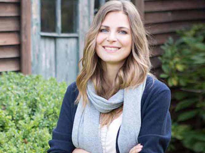 Kvinne står i grønn hage