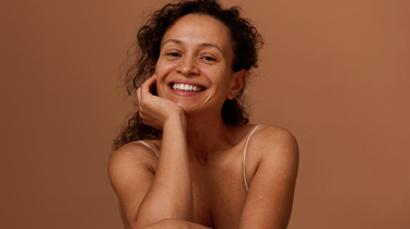 Smilende kvinne i studiobakgrunn