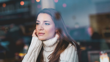 ung kvinne som stirrer ut vinduet. 