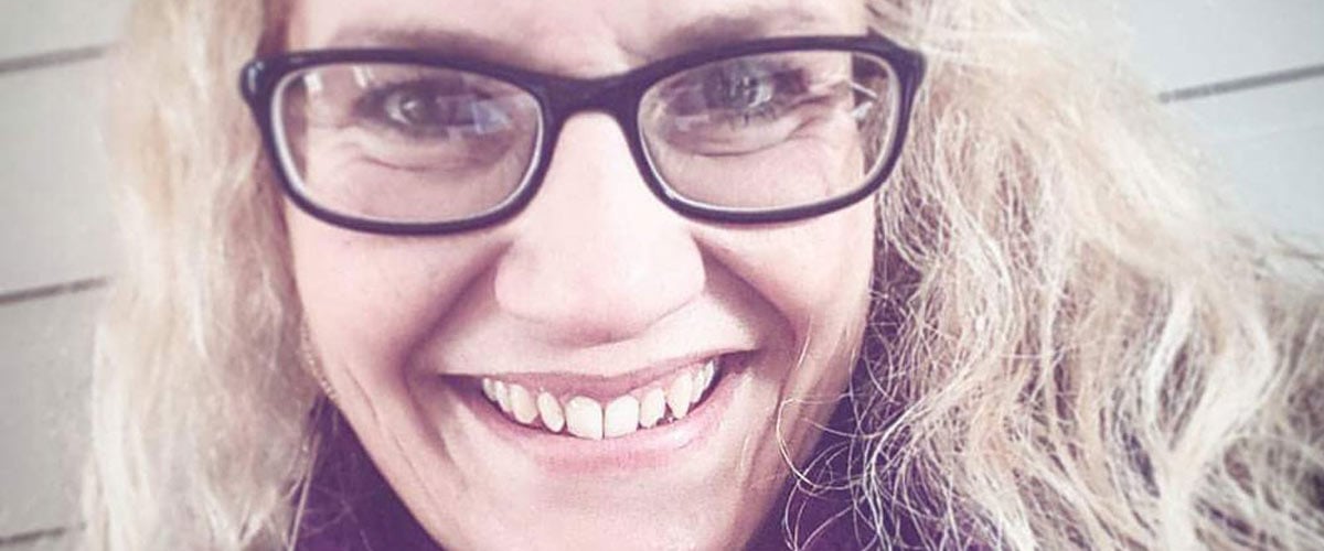 Smilende dame med briller.