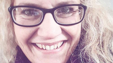 Smilende dame med briller.