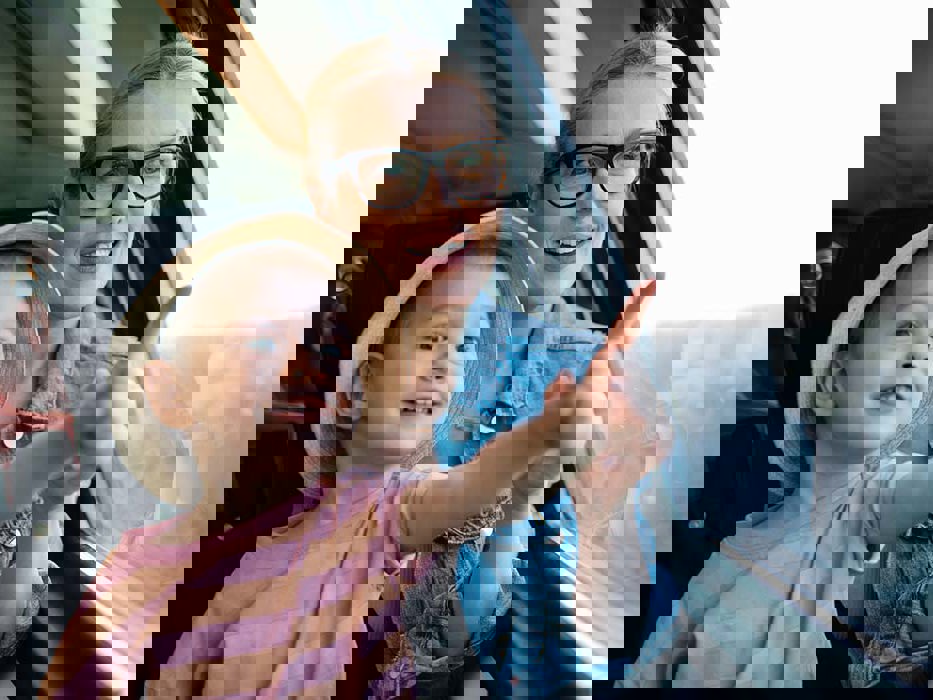 mor og datter sitter på toget og ser ut vinduet.