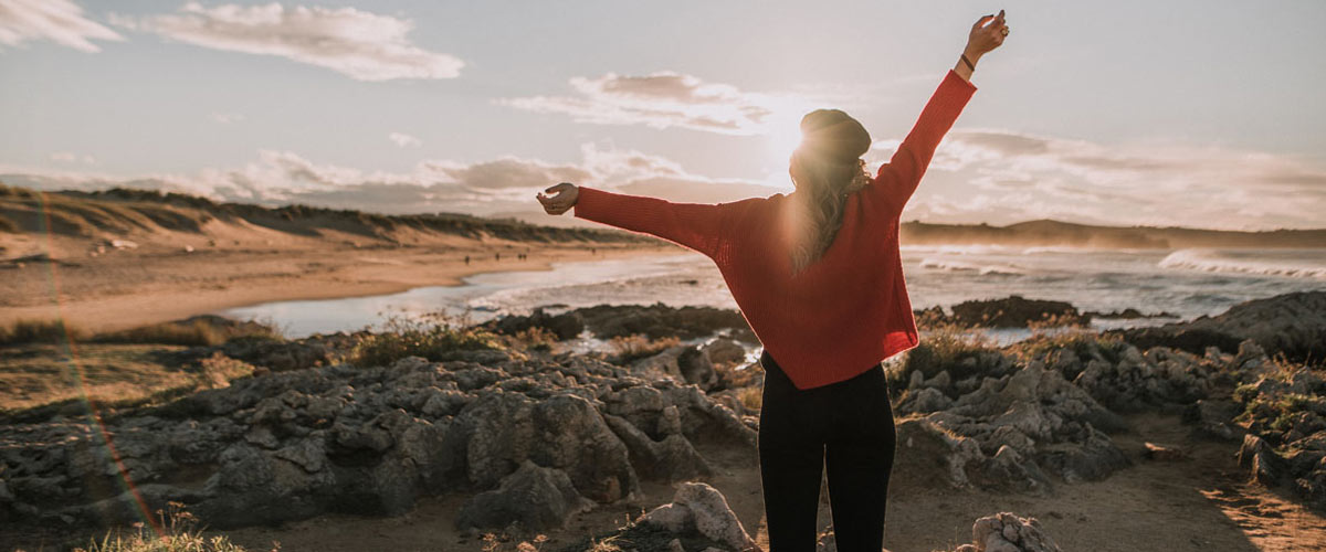 kvinne på utsiktspunkt med henda i været. 