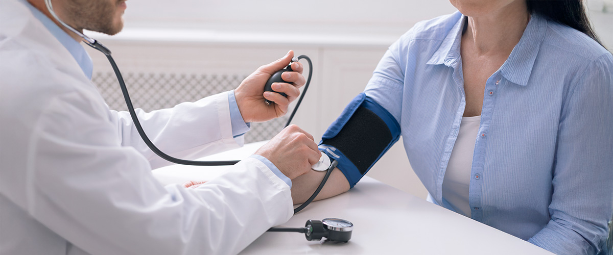 Lege måler blodtrykket til pasient