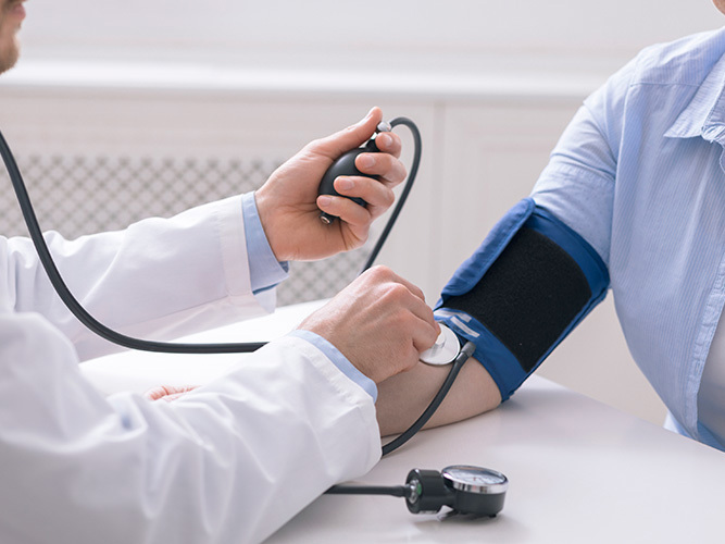 Lege måler blodtrykket til pasient