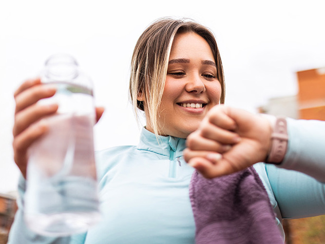 Kvinne ser på klokken når hun er i aktivitet.